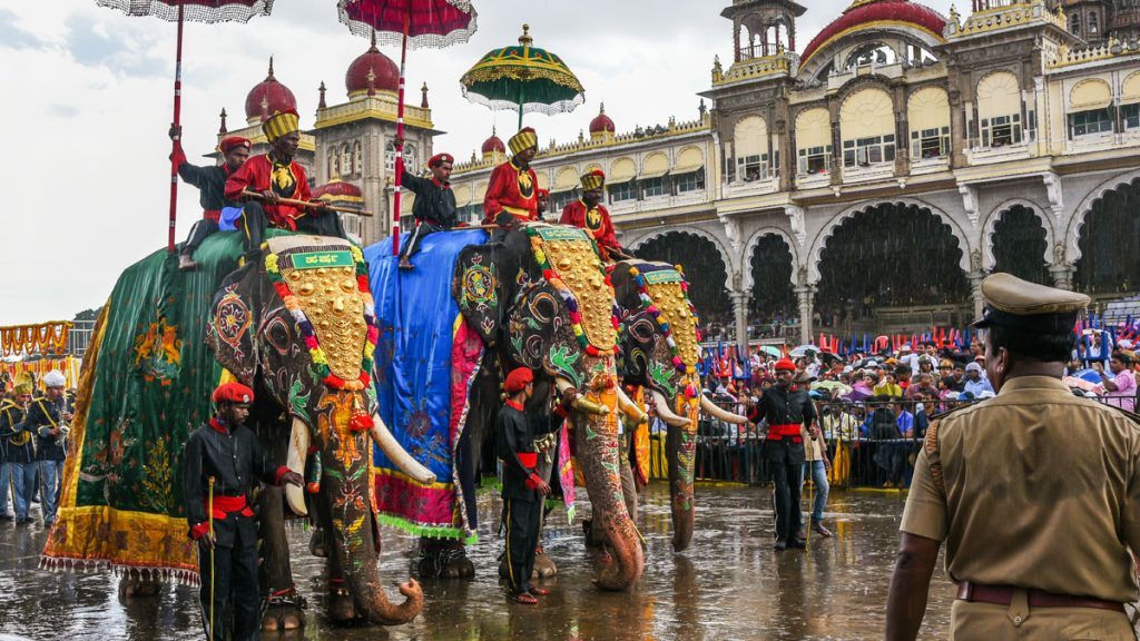 Men riding on decorated elephant with umbrella at Mysore maharajas Palace.