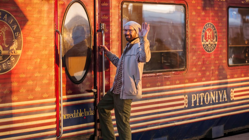 A foreign traveller waving his hand near the Maharaja Express