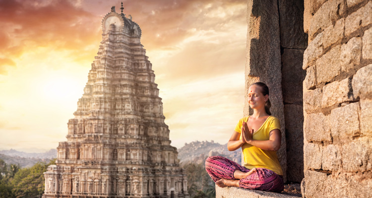 Woman with Namaste mudra sitting near Virupaksha temple in Hampi, Karnataka, India