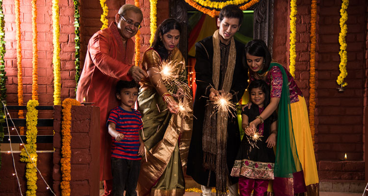 Indian Family celebrating Diwali festival with fire crackers.