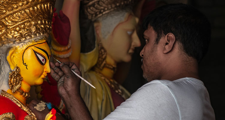 A artist creating a goddess Durga idol on the occasion of Durga Puja festival.